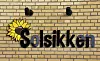 Billedet viser et skilt med teksten Solsikken, som kan findes på børnehusets facade.