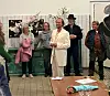 Publikum står i en kreds omkring Peter Kirk, som er klædt i hvidt.