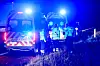 Ambulancer og redningsfolk med blåblink ved ulykke på mørk motorvej.