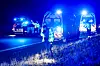 Politi og redningskøretøjer med blå blink ved motorvejsstrækning i mørke.