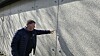 Søren Hansen, Ravnsborghallen, peger på detalje i grå betonvæg udendørs