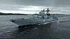 Et gråt russisk krigsskib sejler på mørkt, bølget hav under overskyet himmel.