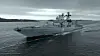 Et gråt russisk krigsskib sejler på mørkt, bølget hav under overskyet himmel.