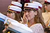 Kvinde i hvid uniformshue tørrer øjnene under en højtidelig ceremoni.