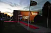 Biografbygning i skumringen med rød løber og oplyst bio-skilt ved indgangen.