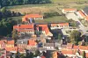 Luftfoto af Rødby Skole med skolebygninger, hal og børnehave omgivet af røde tage.