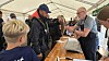Mennesker taler ved en informationsstand under et telt.