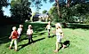 Børn leger og løber på en græsplæne i Lienlund-parken.