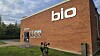 Udvendig rød murstensfacade med stort 'bio'-skilt og indgang ved siden af græsareal.